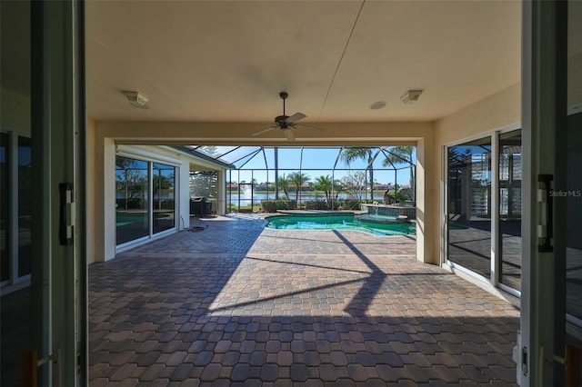 view of swimming pool featuring ceiling fan, a patio, and glass enclosure