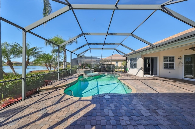 view of swimming pool with an in ground hot tub, ceiling fan, a water view, glass enclosure, and a patio