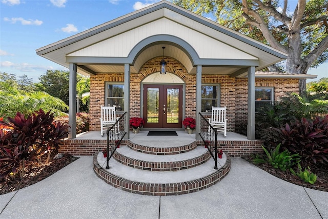 entrance to property featuring covered porch and french doors