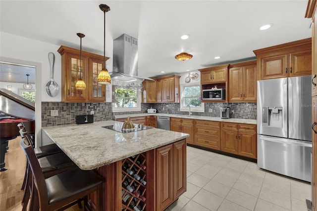 kitchen featuring stainless steel appliances, a kitchen breakfast bar, island exhaust hood, kitchen peninsula, and decorative backsplash