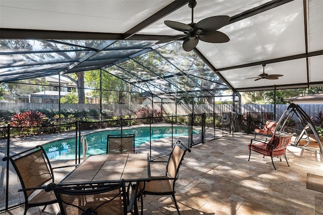 view of pool with glass enclosure and a patio area