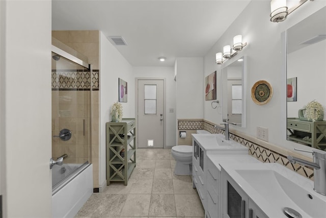 full bathroom featuring tile patterned floors, vanity, enclosed tub / shower combo, and toilet