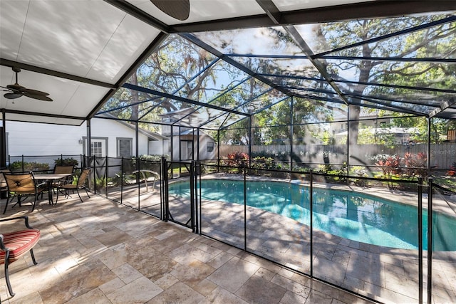 view of swimming pool featuring a lanai, a patio area, ceiling fan, and a storage shed