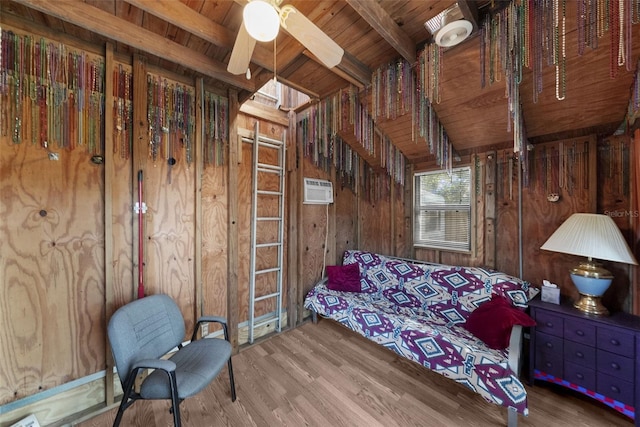 living area with beamed ceiling, hardwood / wood-style floors, wooden walls, and wood ceiling