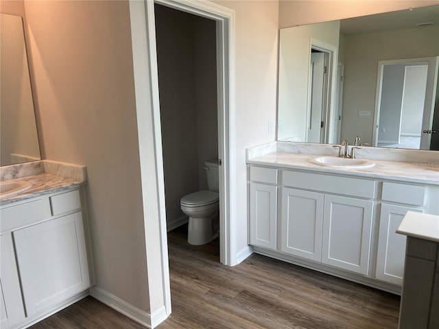 16033 7th Ave E, Bradenton, FL 34212 - bathroom featuring two vanities, wood finished floors, toilet, and baseboards