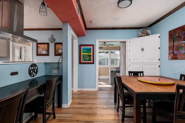 dining space featuring a textured ceiling, light hardwood / wood-style flooring, ceiling fan, and crown molding