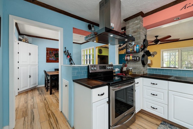 kitchen with island exhaust hood, white cabinets, light hardwood / wood-style flooring, and stainless steel range with electric stovetop