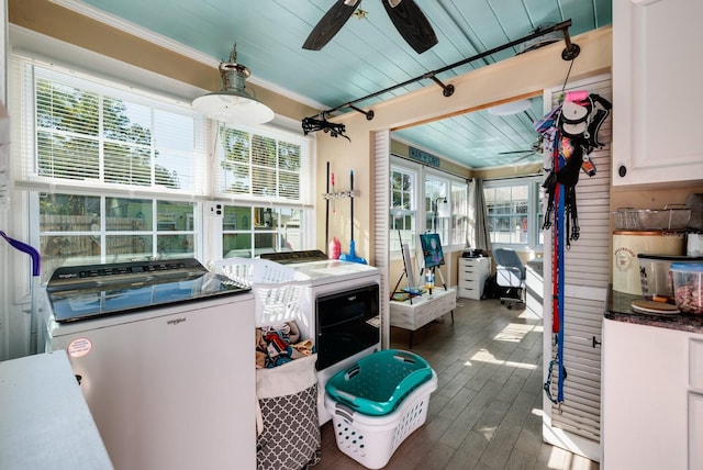 washroom featuring washer and clothes dryer, dark hardwood / wood-style flooring, plenty of natural light, and cabinets