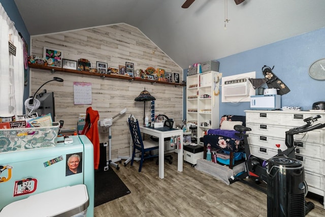 home office with wooden walls, ceiling fan, vaulted ceiling, and hardwood / wood-style flooring