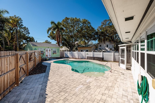 view of swimming pool with a patio area and an outbuilding