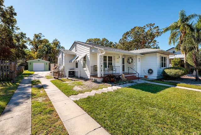 bungalow featuring a front yard, an outdoor structure, and a garage