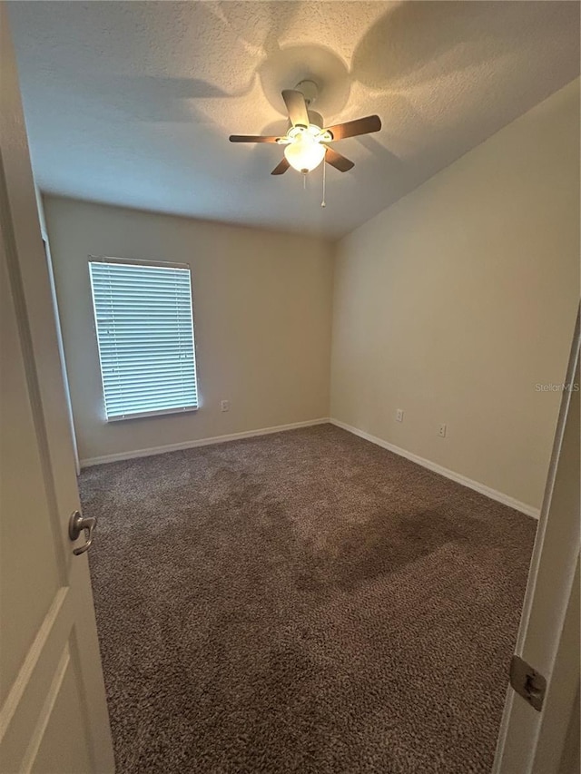 carpeted empty room with a textured ceiling and ceiling fan