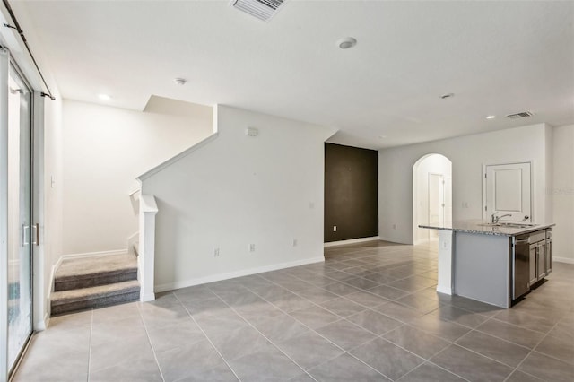 unfurnished living room featuring sink and light tile patterned floors