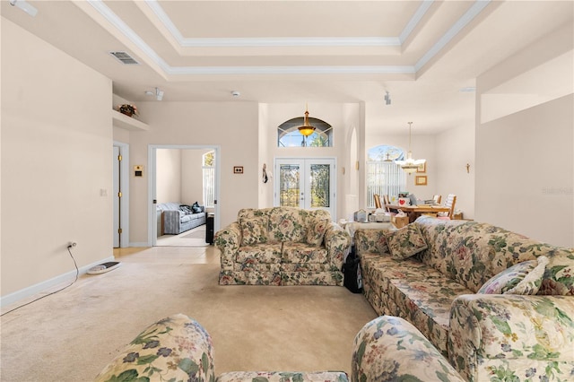 carpeted living room with french doors, a tray ceiling, and ornamental molding