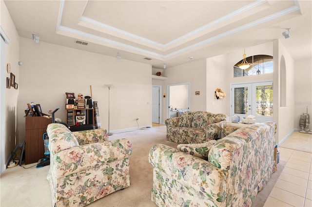 carpeted living room with a tray ceiling, crown molding, and french doors