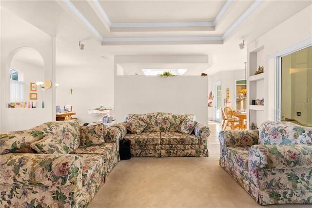 carpeted living room with a raised ceiling, ornamental molding, and a wealth of natural light