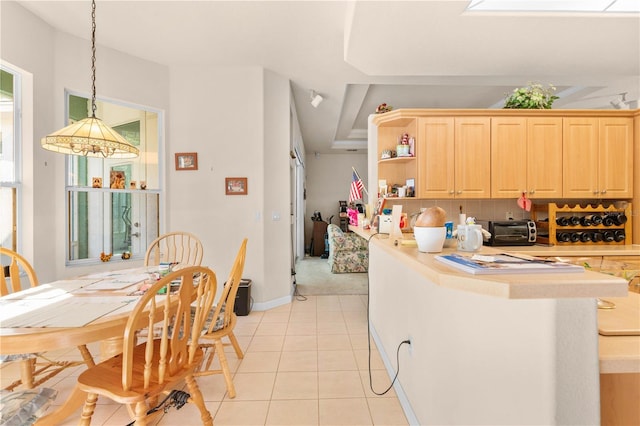 kitchen featuring decorative backsplash, light brown cabinetry, light tile patterned floors, decorative light fixtures, and a notable chandelier