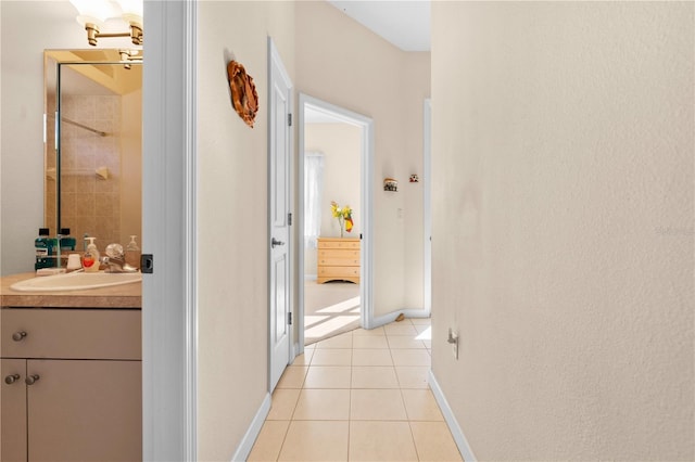 corridor with sink and light tile patterned flooring