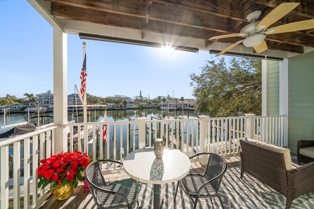 deck with a water view and ceiling fan