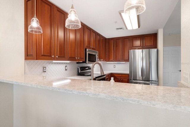 kitchen with pendant lighting, backsplash, and appliances with stainless steel finishes