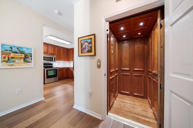 corridor with light hardwood / wood-style floors