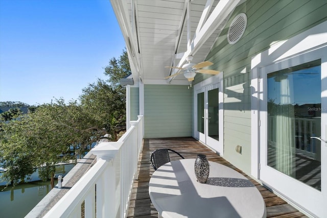 wooden balcony with a wooden deck, ceiling fan, and french doors