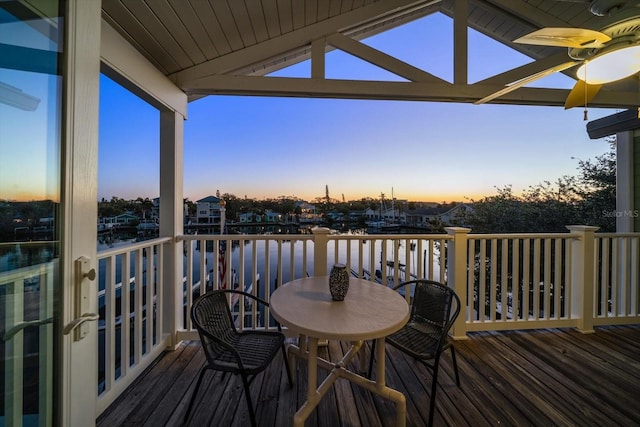 deck at dusk featuring ceiling fan