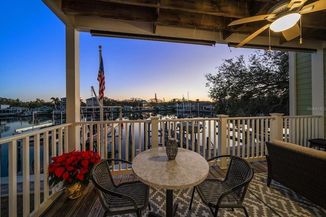 deck at dusk featuring ceiling fan