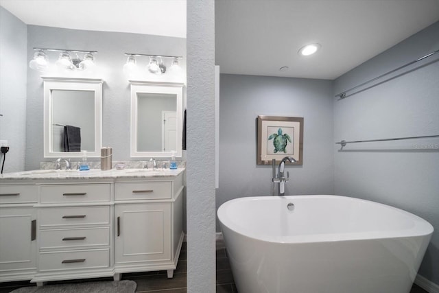 bathroom featuring a washtub and vanity