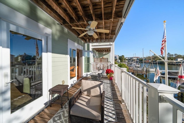 balcony featuring ceiling fan, a water view, and french doors