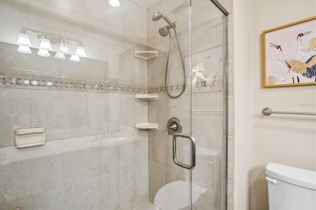 bathroom with toilet and a shower with shower door