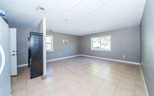 unfurnished room featuring a wall mounted AC and light tile patterned floors