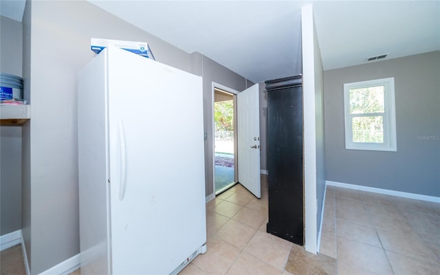 hall featuring light tile patterned floors