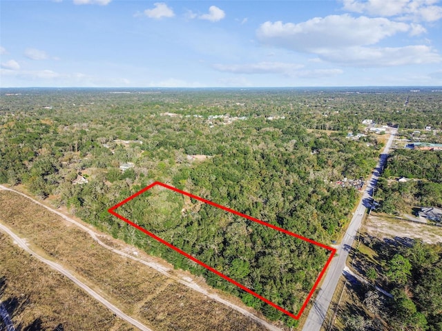 drone / aerial view featuring a wooded view