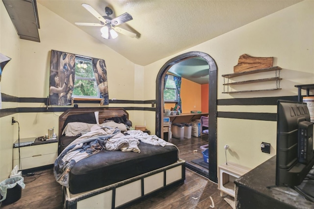 bedroom with dark wood-type flooring, lofted ceiling, multiple windows, and a textured ceiling