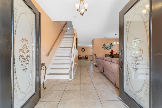 tiled foyer entrance featuring an inviting chandelier