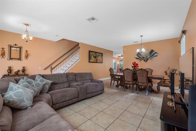 tiled living room featuring ceiling fan with notable chandelier