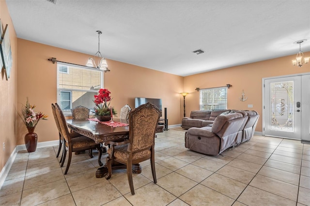 dining room featuring light tile patterned floors and a notable chandelier