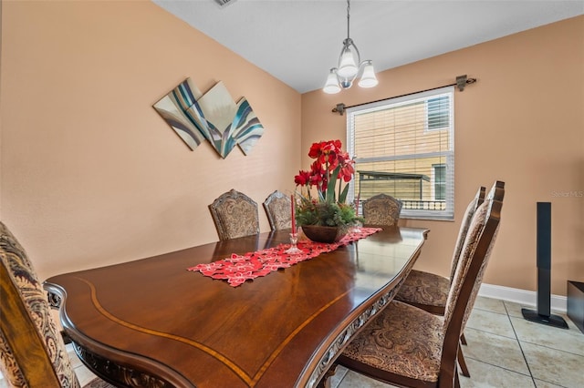 dining room with light tile patterned floors and an inviting chandelier