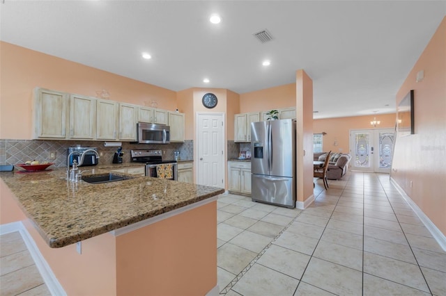 kitchen with backsplash, french doors, sink, appliances with stainless steel finishes, and kitchen peninsula