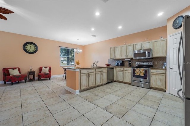 kitchen with kitchen peninsula, stainless steel appliances, sink, decorative light fixtures, and light tile patterned flooring