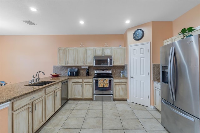 kitchen with decorative backsplash, sink, light tile patterned flooring, and appliances with stainless steel finishes