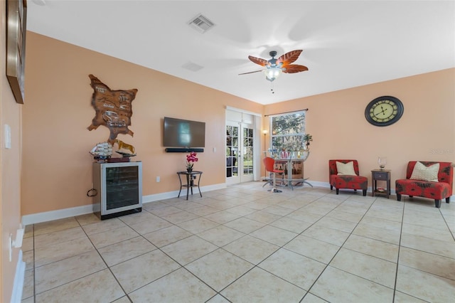 sitting room featuring ceiling fan, light tile patterned floors, and beverage cooler