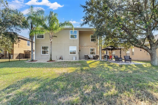 back of house with outdoor lounge area, a patio, and a lawn