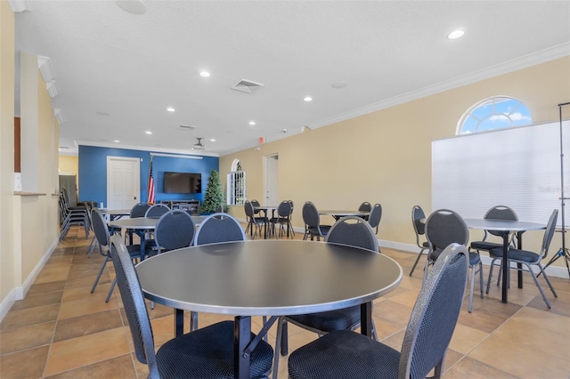 dining area featuring ornamental molding and light tile patterned flooring