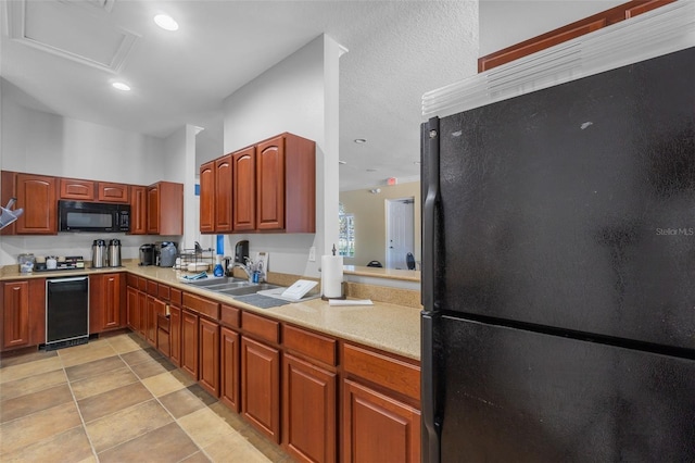 kitchen featuring sink, light tile patterned floors, and black appliances