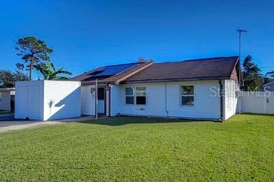 ranch-style house with a front yard and solar panels