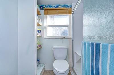 bathroom with toilet and a shower