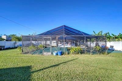 exterior space featuring a yard and glass enclosure