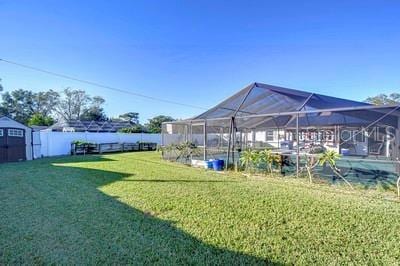 view of yard featuring a lanai and a shed